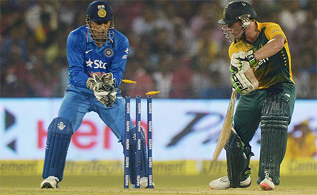 India's captain Mahendra Singh Dhoni looks on as South Africa's AB de Villiers is clean-bowled during the second T20 cricket match between India and South Africa at The Barabati Stadium in Cuttack on October 5, 2015. (AFP)