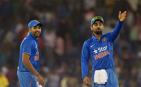 India's Virat Kohli (right) talks with Rohit Sharma as play is interrupted by spectators throwing bottles onto the pitch during the second T20 cricket match between India and South Africa at The Barabati Stadium in Cuttack on October 5, 2015. (AFP)