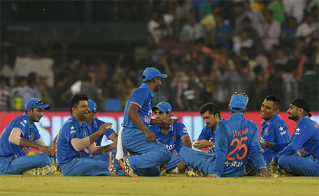 India's captain Mahendra Singh Dhoni (second right) sits with teammates as play is interrupted by spectators throwing bottles onto the pitch during the second T20 cricket match between India and South Africa at The Barabati Stadium in Cuttack on October 5, 2015. (AFP)