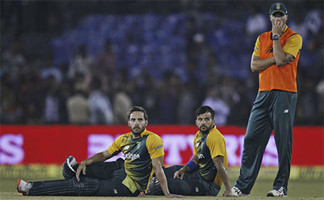 South African batsmen Farhaan Behardien (left) and Jean-Paul Duminy sit and watch as their second Twenty20 cricket match against India is disrupted after spectators threw bottles in Cuttack, India, Monday, Oct. 5, 2015. (AP)