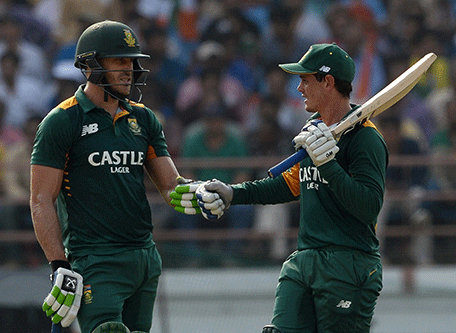 South Africa's batsmen Quinton de Kock (R) and Faf du Plessis greet each other during the third one day international (ODI) cricket match between India and South Africa at The Saurashatra Cricket Association Stadium in Rajkot on October 18, 2015.   AFP