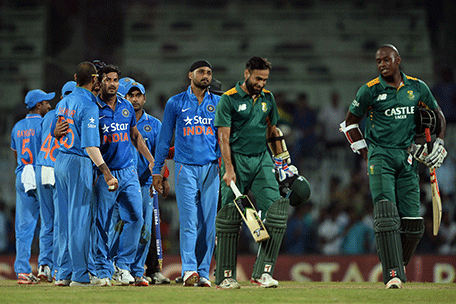 Indian cricketers congratulate each other while the last standing batsman of South African team Imran Tahir (2R) and Kagiso Rabada (R) walk back to the pavilion after India won the one day international (ODI) cricket match between India and South Africa by 35 runs at The M.A Chidambaram Stadium Chepauk in Chennai on October 22, 2015. AFP