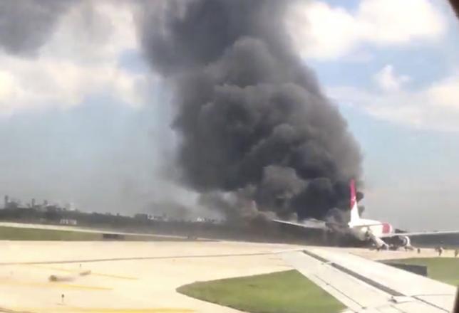 A still image from a handout video footage by Mike Dupuy, a passenger in another airplane, shows Dynamic International Airways' Boeing 767's engine on fire in Fort Lauderdale, Florida, October 29, 2015. (Reuters)
