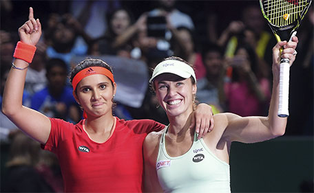 Sania Mirza (left) of India and Martina Hingis of Switzerland celebrate after winning the doubles final at the WTA tennis finals in Singapore on Sunday, Nov. 1, 2015. (AP)