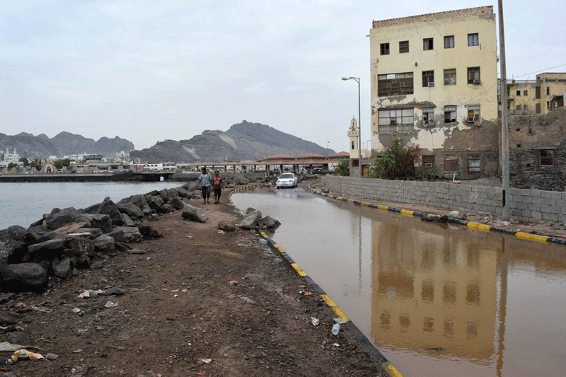 Yemenis walk along a flooded street in Aden on November 3, 2015, following a tropical cyclone that has slammed into the country. (AFP)