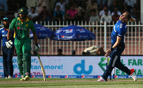 England's Chris Woakes (right) bowls as Pakistan's Azhar Ali looks on during the third One Day International between Pakistan and England at the Sharjah Cricket Stadium in Sharjah on November 17, 2015. (AFP)