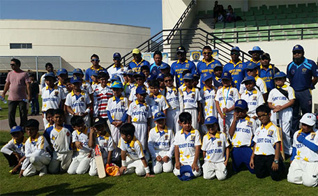 Rumesh Ratnayake with members of the Deserts Cubs Cricket Academy after a training session. (Supplied)