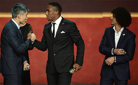Chinese player Zheng Zhi (left) congratulates Ahmad Khalil (centre) of UAE for winning the AFC Player of the Year Award as UAE player Omar Abdulrahman looks on during the Asian Football Confederation (AFC)'s Annual Awards ceremony in Gurgaon, some 40 kms west of New Delhi on November 29, 2015. (AFP)