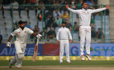 Indian batsman Shikhar Dhawan, left runs between the wickets as  South African bowler Dane Piedt, right jumps in the air on the third day of the fourth test cricket match between India and South Africa in New Delhi, India, Saturday, Dec. 5, 2015. (AP)
