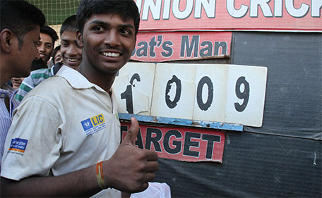 Mumbai schoolboy Pranav Dhanawade, 15, poses next to the score board after smashing a 117-year-old record for the highest number of runs scored in one innings in Mumbai on January 5, 2016. (AFP)