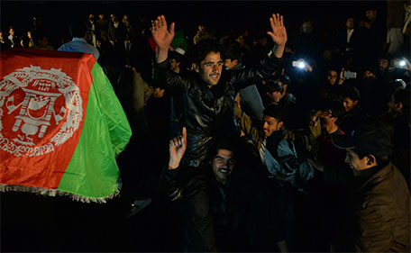 Afghan cricket fans celebrate their team's victory in the match between Afghanistan and Zimbabwe as they watch it on a big screen at a stadium in Jalalabad on January 6, 2016. (AFP)
