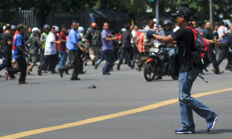 A man is seen holding a gun towards the crowd in central Jakarta, Indonesia, in this picture provided to Reuters by Xinhua News Agency on January 14, 2016. (Reuters)
