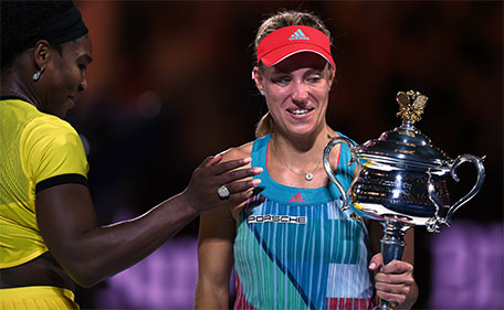 Germany's Angelique Kerber (right) holds the Daphne Akhurst Memorial Cup after her victory during the women's singles final against Serena Williams of the US on day thirteen of the 2016 Australian Open tennis tournament in Melbourne on January 30, 2016. (AFP)