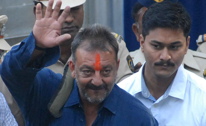 Indian Bollywood actor Sanjay Dutt (C) waves as he is escorted by officials from Yerwada Jail in Pune on February 25, 2016. (AFP)