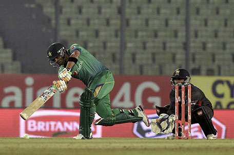 Pakistan cricketer  Umar Akmal (left) plays a shot as the United Arab Emirates wicketkeeper Swapnil Patil (R) looks on during the Asia Cup T20 cricket tournament match between Pakistan and United Arab Emirates at the Sher-e-Bangla National Cricket Stadium in Dhaka on February 29, 2016. (AFP)