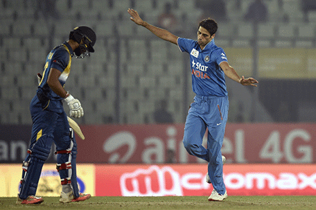 Indian cricketer  Ashish Nehra (R) reacts after the dismissal of the Sri Lanka cricketer Dinesh Chandimal (L) during the Asia Cup T20 cricket tournament match between India and Sri Lanka at the Sher-e-Bangla National Cricket Stadium in Dhaka on March 1, 2016. AFP