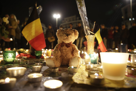 A Belgian flag, candles and a Teddy bear are pictured as people gather at a makeshift memorial on the Place de la Bourse (Beursplein) in Brussels. (AFP)