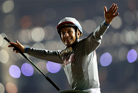 Victor Espinoza, who competed with California Chrome from USA, celebrates after winning the ninth and final race at the Dubai World Cup - Meydan Racecourse, Dubai - 26/3/16. (Reuters)