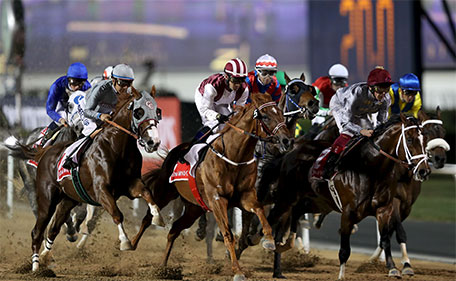 Victor Espinoza (left) rides California Chrome from USA to the finish line to win the ninth and final race of theDubai World Cup at Meydan Racecourse, Dubai - 26/3/16. (Reuters)