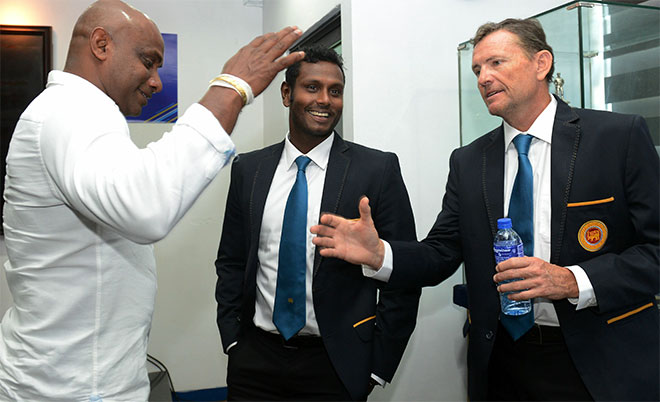 Sri Lankan cricket team head coach Graham Ford (right) shakes hands with former skipper Sanath Jayasuriya (left) as captain Angelo Mathews looks on at a press conference as the team prepare to leave for their forthcoming England tour in Colombo on May 4, 2016. (AFP)