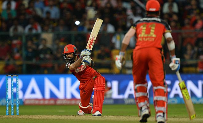Royal Challengers Bangalore captain and batsman Virat Kohli plays a shot while his partner K L Rahul looks on during the 2016 Indian Premier League (IPL) Twenty20 cricket match between Royal Challengers Bangalore and Kings XI Punjab, at The M. Chinnaswamy Stadium in Bangalore on May 18, 2016. (AFP)