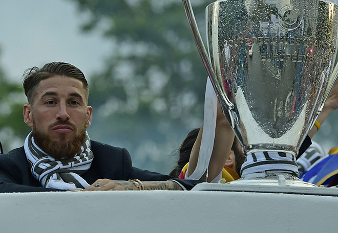 Real Madrid's defender Sergio Ramos  rides on the bus beside the trophy as the team celebrate on Plaza Cibeles in Madrid on May 29, 2016 after the UEFA Champions League final foobtall match between Real Madrid CF, Club Atletico de Madrid held in Milan, Italy. (AFP)