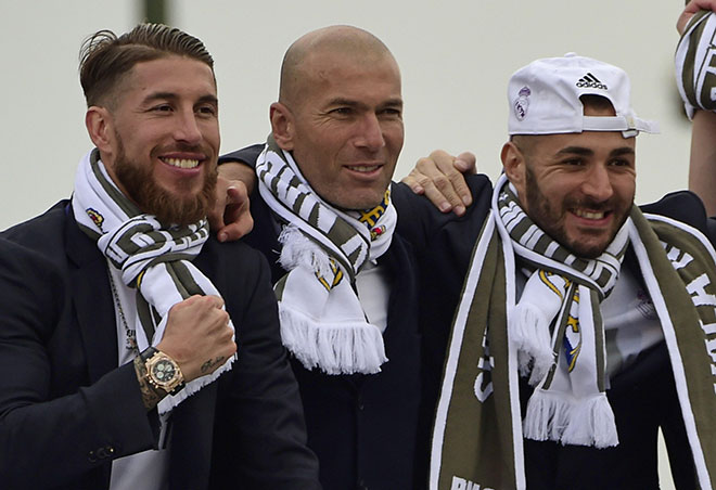Real Madrid's defender Sergio Ramos (left), Real Madrid's French coach Zinedine Zidane (centre) and Real Madrid's French forward Karim Benzema celebrate the team's win on Plaza Cibeles in Madrid on May 29, 2016 after the UEFA Champions League final foobtall match between Real Madrid CF, Club Atletico de Madrid held in Milan, Italy. (AFP)