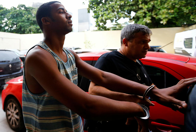 Rai de Souza, 22, suspected of being involved in the gang rape of a teenage girl, with a video of the assault circulated widely on social media, is escorted at the Police Station for crimes against minors in Rio de Janeiro, Brazil, May 30, 2016 (Reuters)