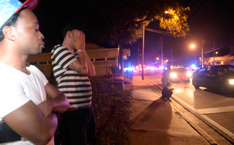 Jermaine Towns, left, and Brandon Shuford wait down the street from a multiple shooting at a nightclub in Orlando, Fla., Sunday, June 12, 2016. Towns said his brother was in the club at the time. A gunman opened fire at a nightclub in central Florida, and multiple people have been wounded, police said Sunday. (AP)