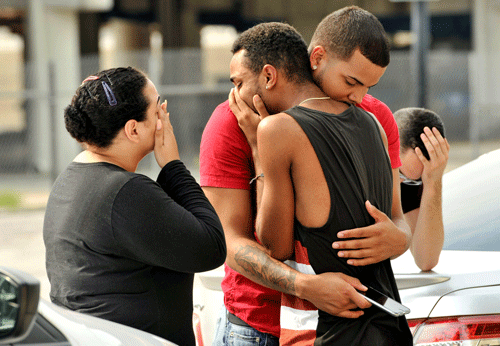 Friends and family members embrace outside the Orlando Police Headquarters during the investigation of a shooting at the Pulse night club, where as many as 20 people have been injured after a gunman opened fire, in Orlando, Florida, on June 12, 2016.  (REUTERS)