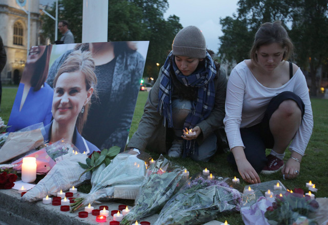 Floral tributes and candles are placed by a picture of slain Labour MP Jo Cox at a vigil in Parliament square in London. (AFP)
