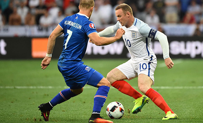 Iceland's forward Johann Berg Gudmundsson (left) and England's forward Wayne Rooney vie for the ball during the Euro 2016 round of 16 football match between England and Iceland at the Allianz Riviera stadium in Nice on June 27, 2016. (AFP)