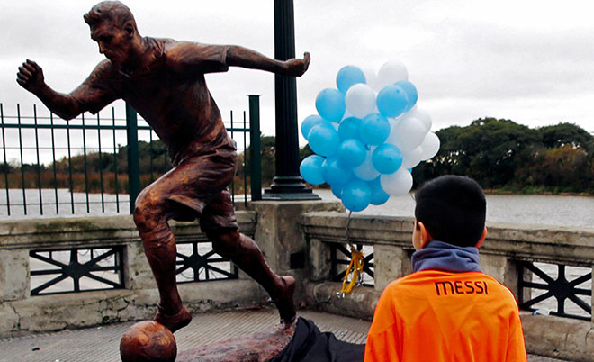A boy wears a Lionel Messi jersey as he approaches the statue of Argentina's soccer player Messi after it was unveiled in Buenos Aires, Argentina, June 28, 2016. (Reuters)