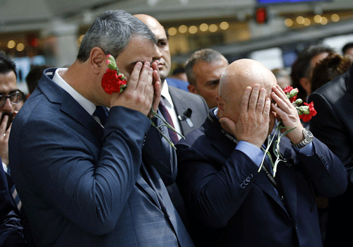 Men react as family members, colleagues and friends of the victims of Tuesday blasts gather for a memorial ceremony at the Ataturk Airport in Istanbul, Thursday, June 30, 2016. Turkish authorities have banned distribution of images relating to the Ataturk airport attack within Turkey.(AP)