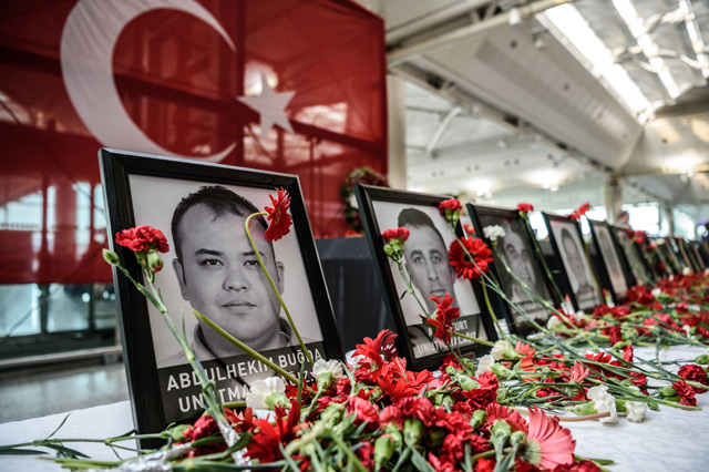 Cloves left by airport employees next to killed airport employees pictures at Ataturk airport international terminal in Istanbul on June 30, 2016 two days after the triple suicide bombing and gun attack occurred at Istanbul's Ataturk airport. (AFP)