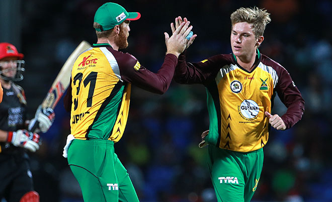 Adam Zampa (right) and Martin Guptill of Guyana Amazon Warriors celebrate the wicket of Brad Hodge, left, of St Kitts and Nevis Patriots during Match 2 of the Hero Caribbean Premier League between St Kitts & Nevis Patriots and Guyana Amazon Warriors at Warner Park in Basseterre, St Kitts. (CPL/Sportsfile)