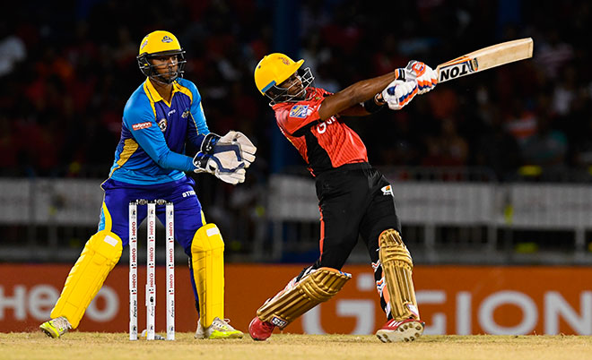 Dwayne Bravo of Trinbago Knight Riders hits 4 during Match 3 of the Hero Caribbean Premier League between Trinbago Knight Riders and Tridents at Queen's Park Oval in Port of Spain, Trinidad. The keeper is Nicholas Pooran of Tridents. (CPL/Sportsfile)