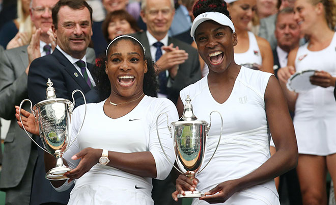 US player Serena Williams (left) and her partner US player Venus Williams pose with the winner's trophies after winning the women's doubles final on the thirteenth day of the 2016 Wimbledon Championships at The All England Lawn Tennis Club in Wimbledon, southwest London, on July 9, 2016. (AFP)