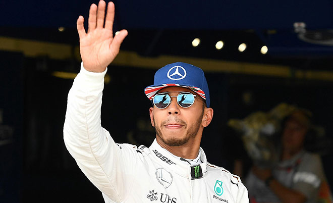 Mercedes AMG Petronas F1 Team's British driver Lewis Hamilton reacts after taking pole position in Sunday's British Formula One Grand Prix, following the qualifying session at Silverstone motor racing circuit in Silverstone, central England, on July 9, 2016. (AFP)