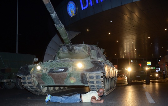 A man lies in front of a tank after Turkish President Tayyip Erdogan urged supporters to take to streets in protest of coup (Reuters)