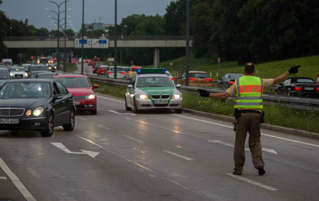 A policeman blocks the traffic at the exit near a shopping mall (the Olympia Einkaufzentrum (OEZ) ) in Munich following shootings. (AFP)