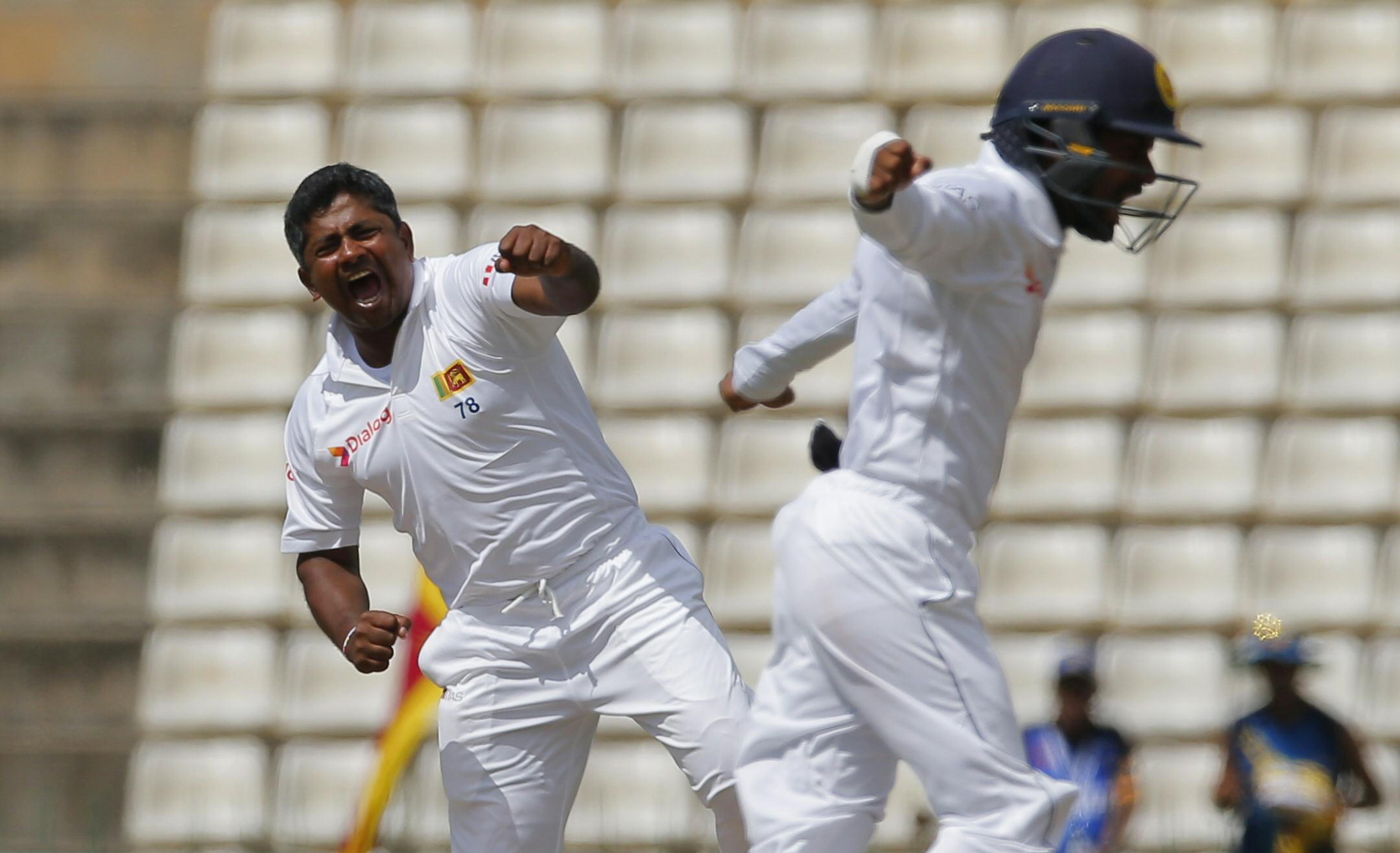 Sri Lanka bowler Rangana Herath (left) celebrates the dismissal of Australia's batsman Usman Khawaja during the second day of the first test cricket match between Sri Lanka and Australia in Pallekele, Sri Lanka, Wednesday, July 27, 2016. (AP)