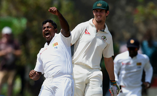 Sri Lankan cricketer Rangana Herath (left) celebrates with teammates after he dismissed unseen Australian batsman Peter Nevill as Mitchell Marsh (right) looks on during the second day of the second Test cricket match between Sri Lanka and Australia at The Galle International Cricket Stadium in Galle on August 5, 2016.  (AFP)
