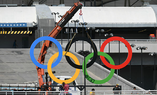 Workers set olympic rings outside the Maracana stadium in Rio de Janeiro on August 5, 2016, ahead of the Rio 2016 Olympic Games' opening ceremony. (AFP)