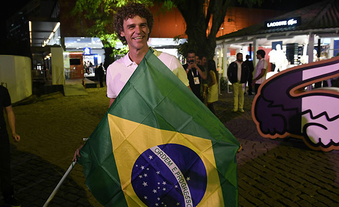 Brazilian former tennis player Gustavo Kuerten holds the national flag at the "Club France" in Rio de Janeiro on August 4, 2016, ahead of the Rio 2016 Olympic Games. (AFP)