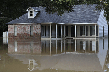 A home is surrounded by flood waters on August 16, 2016 in Denham Springs, Louisiana. Starting last week Louisiana was overwhelmed with flood water causing at least seven deaths and thousands of homes damaged by the flood waters.  AFP