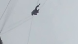 Photo: Man stuck between buildings on a phone wire