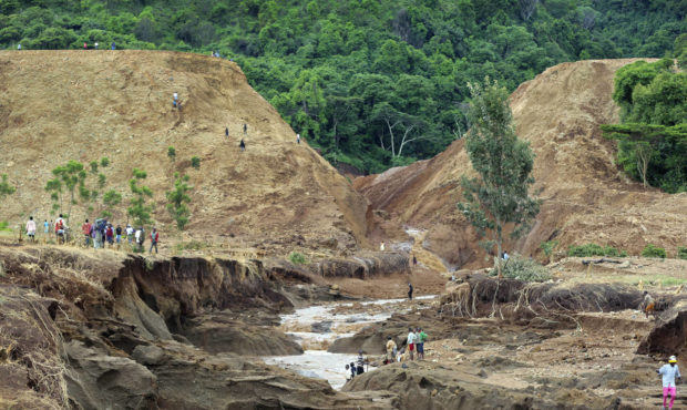 People gather in front of the broken banks of the Patel dam near Solai, in Kenya's Rift Valley. (AP)