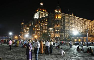 <p><span>Indians walk and gather in front of the Taj Mahal hotel, one of several sites attacked by Islamist militants last month. (AFP)</span></p>